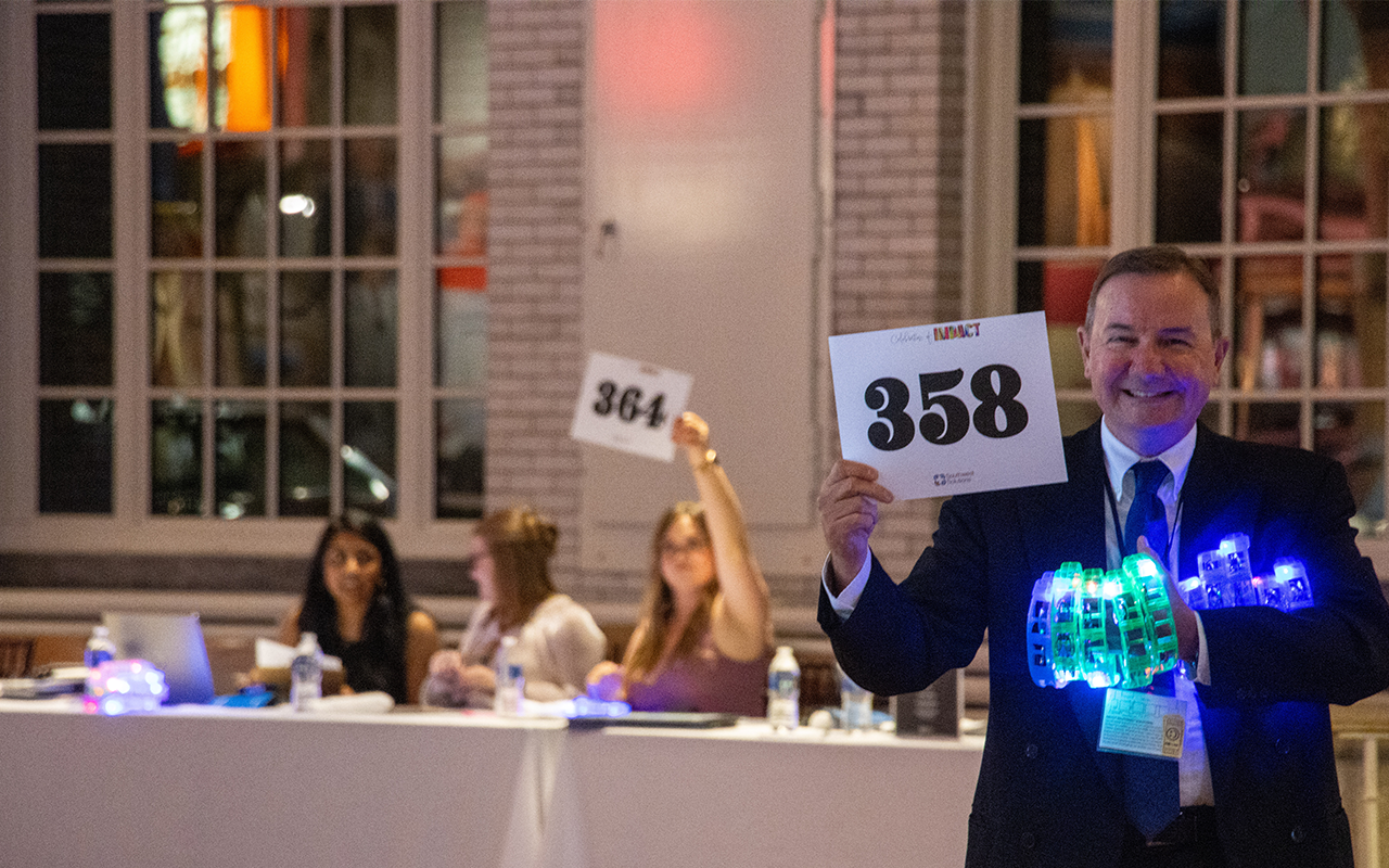 Man holding light up toys and a bidding number