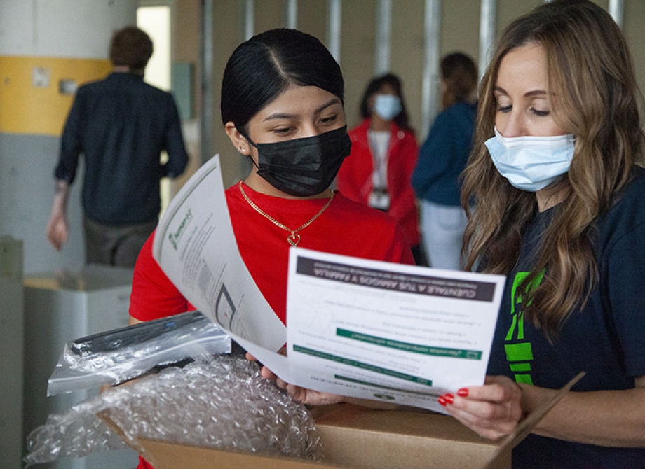 Rebeca Martinez receives a laptop from Jennifer Jambor, Project Manager with human-i-t, at the laptop giveaway event sponsored by Rocket Mortgage.