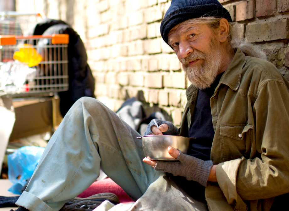 Man looking at viewer eating outside in an alley