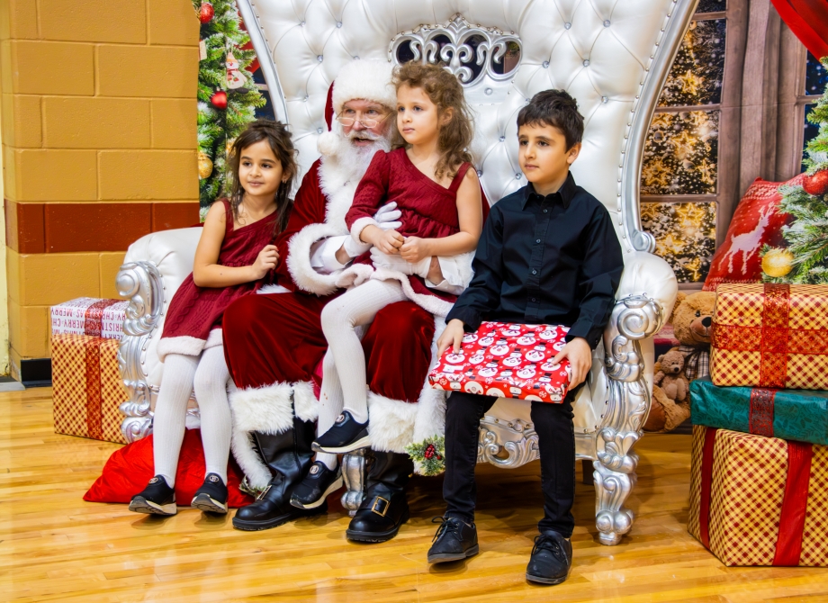 Children sitting with Santa Claus at an event called Santa Day