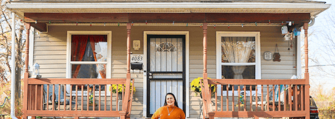 Woman stands in front of a house