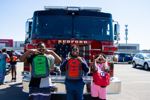 Kids taking photo in front of a truck