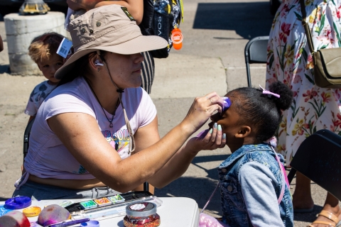 A girl is getting face painting at an event