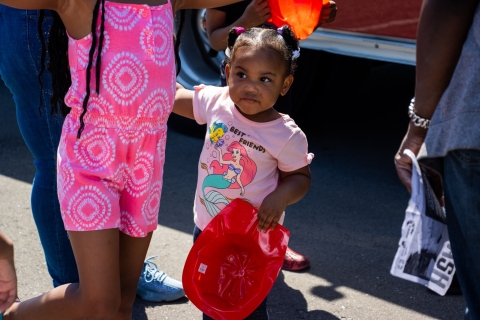 A gril is holding a firefighter helmet