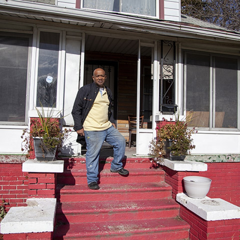 Rev. Larry in front of his home