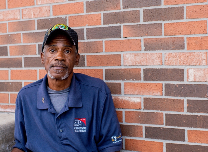 A man sitting on stairs in front of brick wall