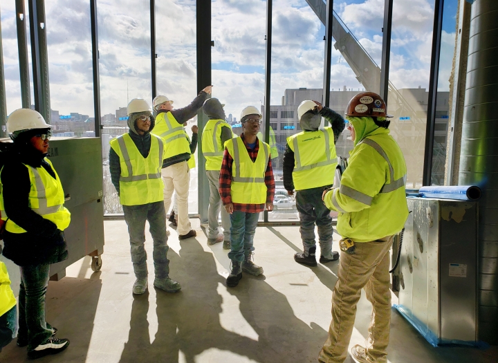 group of individuals standing at a construction site. 